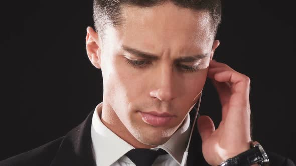 A Close-up of the Face of a Guy Who with a Serious Face Listens To His Special Earpiece