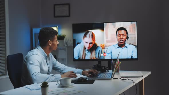 Black Chief Manager Making Video Call on Big Monitor with Colleagues on Quarantine