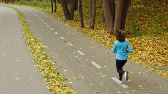 Slow Motion Woman Jogging in Autumn Park