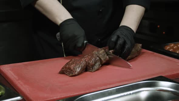 Cook's Hands in Black Gloves Chopping Close Up