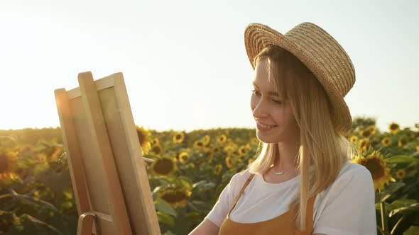 A Woman is Drawing with a Brush on Canvas