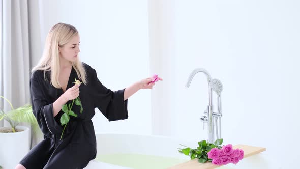 Female Pour Rose Petals Into the Bath