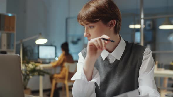 Young Businesswoman Signing Documents Late in Office