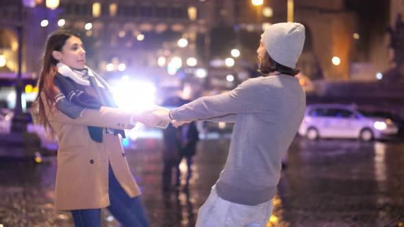 romantic couple - young couple takes hands and turns in the city at night