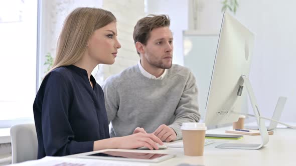 Creative Team Celebrating Success on Desktop in Modern Office