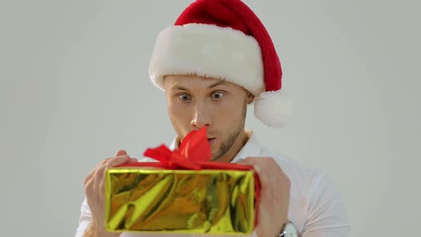 Portrait of a beautiful man in Santa's hat with a fun face image, white background