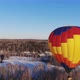Aerial Shot of the People Fly on a Big Bright Balloon Over the Winter Forest - VideoHive Item for Sale