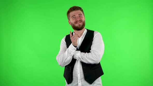 Guy Listens Carefully with a Smile and Then Waves His Finger. Green Screen