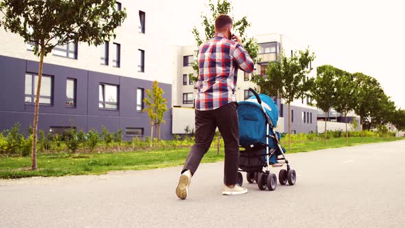 Father with Stroller Calling on Smartphone in City