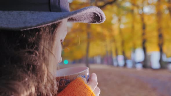 Woman in Woolen Hat Drinking Coffee in Fall Park