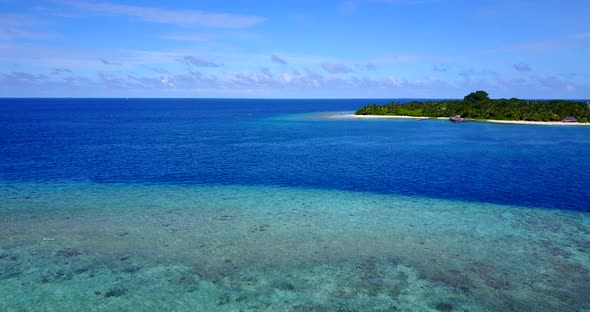 Tropical fly over tourism shot of a sunshine white sandy paradise beach and aqua blue ocean backgrou