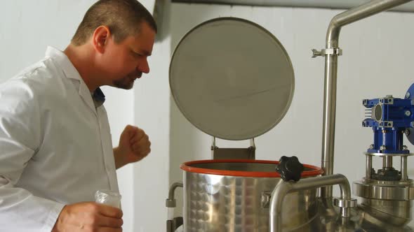 Male worker checking distillation tank in factory 4k