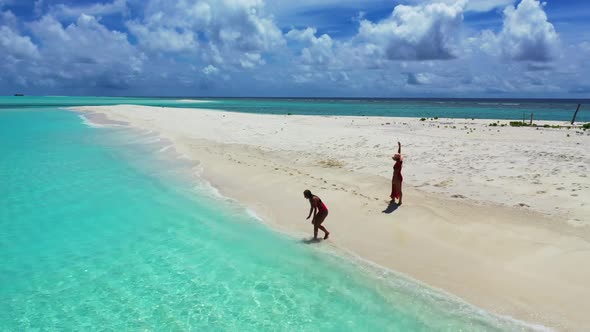 Women happy together on idyllic tourist beach trip by transparent lagoon and white sandy background 