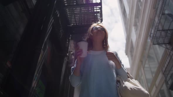 Young Smiling Woman Having Slow Walk in Downtown Enjoying Cup of Tasty Coffee