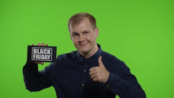 Happy Man Holding Black Friday Inscription, Showing Thumb Up. Guy Rejoicing with Good Sale Discounts