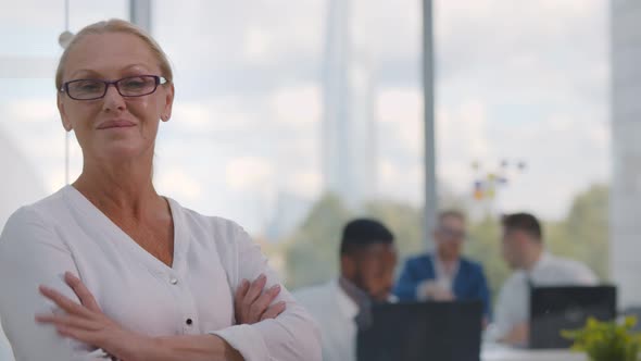 Successful Mature Businesswoman Standing in Modern Office Looking at Camera and Smiling.