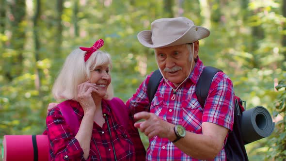 Senior Old Grandmother Grandfather Tourists Enjoying Walking Hiking with Backpacks in Summer Wood