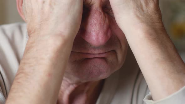 Portrait of a Caucasian pensioner over 70 years old desperate holding his head with his hands