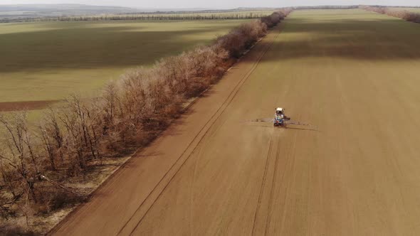 Aerial View Agricultural Machinery Spraying Insecticides on a Plowed Field