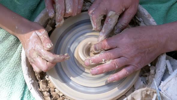 Top View on Potter's Hands Work with Clay on a Potter's Wheel. Slow Motion