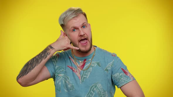 Cheerful Man in Tshirt Looking at Camera Doing Phone Gesture Like Says Hey you Call Me Back