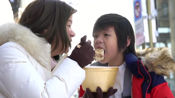 Asian Mother And Her Son Eating Oden Together On Winter