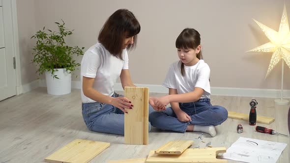 Happy Family Mother and Daughter Assembling Wooden Furniture Together