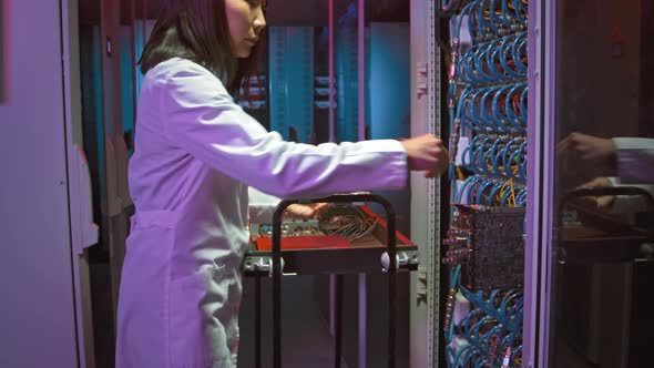 Female Network Engineer Making Repairs in Data Center