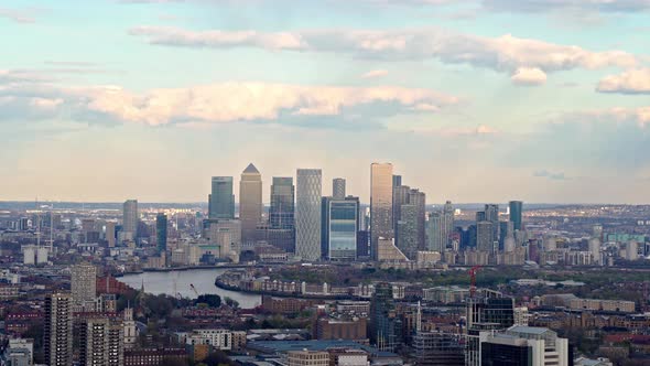 Panning aerial shit showing London Skyline in Canary Wharf District and Cityscape during sunny day w