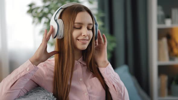 Woman with Closed Eyes Listening Music in Headphones