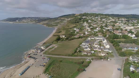 Aerial of Charmouth, Dorset. On a sunny day. Tracking back and curving around to reveal more of the