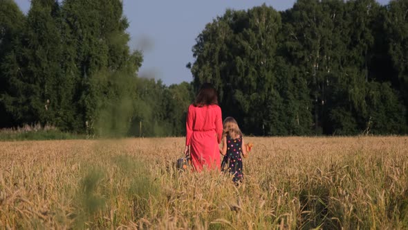 Little Girl with Mother Walking Through a Field