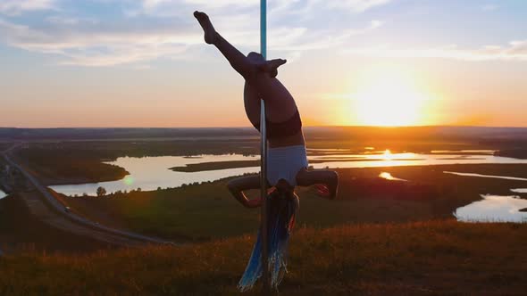 Pole Dance in Nature - Young Woman Holding By the Dancing Pole with Her Legs on Sunset