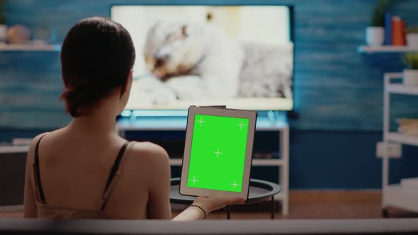 Caucasian Woman Holding Green Screen Vertically on Digital Tablet