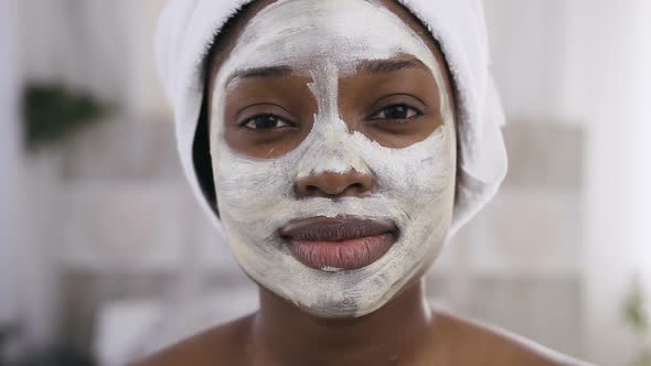 Afro-American Girl with White Towel on Head Having a Cleansing Mask on Face