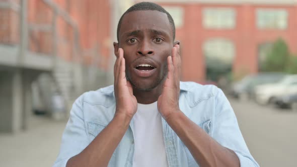 Outdoor Portrait of Excited African Man Reacting to Loss