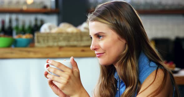 Woman having coffee in cafeteria