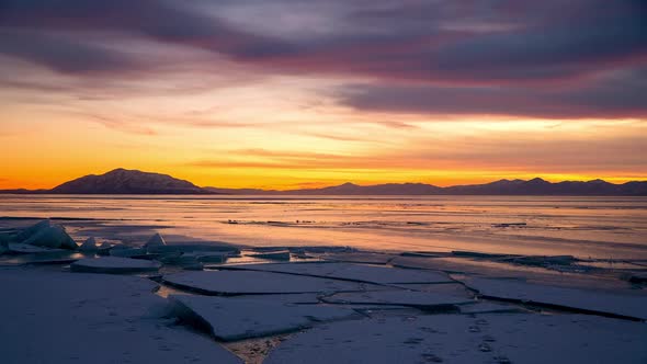 Looking over frozen lake during colorful sunset in winter