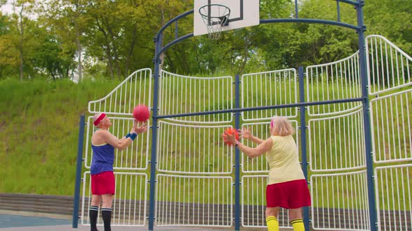 Senior Old Basketball Team Man and Woman Playing Game Throwing Ball Into Basket at Stadium Court