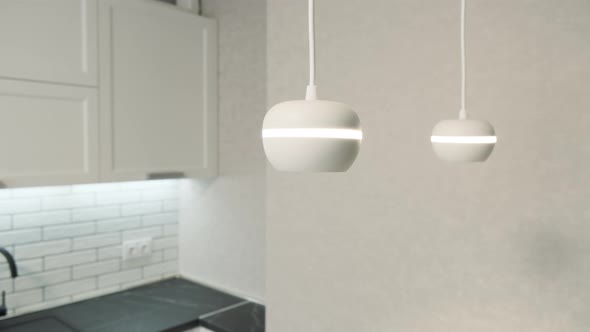 White Ceiling Lights in a Modern Minimalist Kitchen Interior. Elegant Modern Kitchen with White