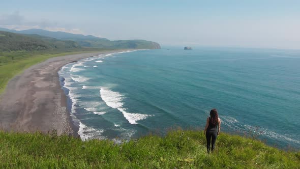 Happy Woman on the Edge of the Cliff with the View of Sea