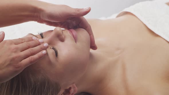 Young, healthy and beautiful woman gets massage therapy in the spa salon.