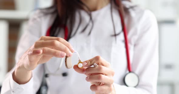 ENT Doctor is Holding Hearing Aid for Patient with Hearing Problem