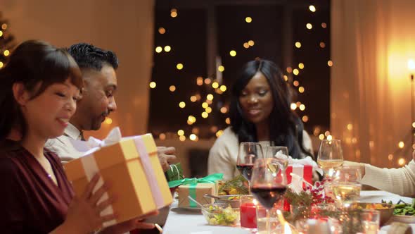 Friends Having Christmas Feast and Giving Presents