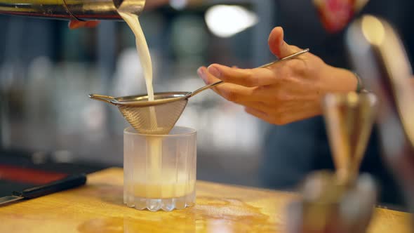 4K Male bartender preparing cocktail drink serving to customer on bar counter at luxury bar.