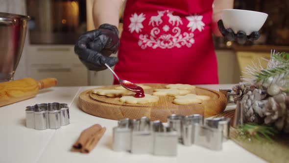 View of a Woman Hand Making a Gingerbread Cookie Using a Spoon Puts the Jam on the Cookies