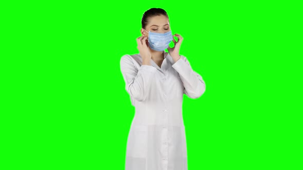 Nurse in Surgery Puts Off the Mask and Smile. Green Screen