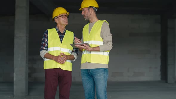 Two caucasian engineers on construction site. Shot with RED helium camera in 8K