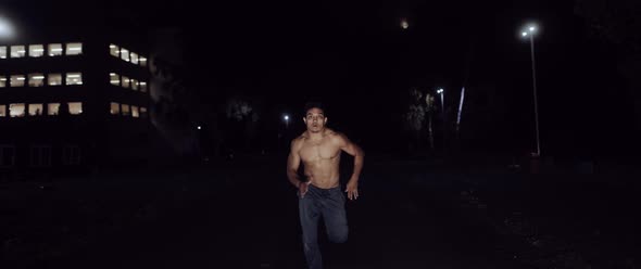 Muscular Man running in the Dark