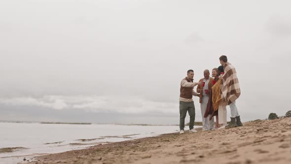 Friends Standing on Sandy Seashore